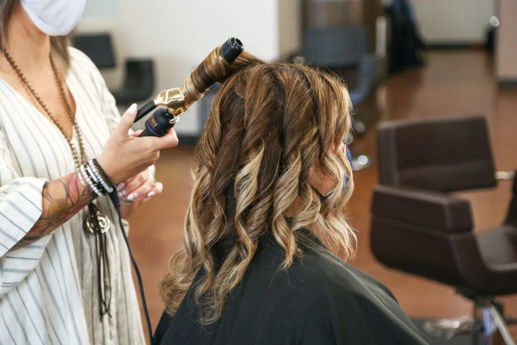 stylist tonging a clients hair