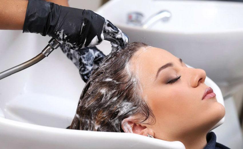 woman getting her hair shampooed at backwash