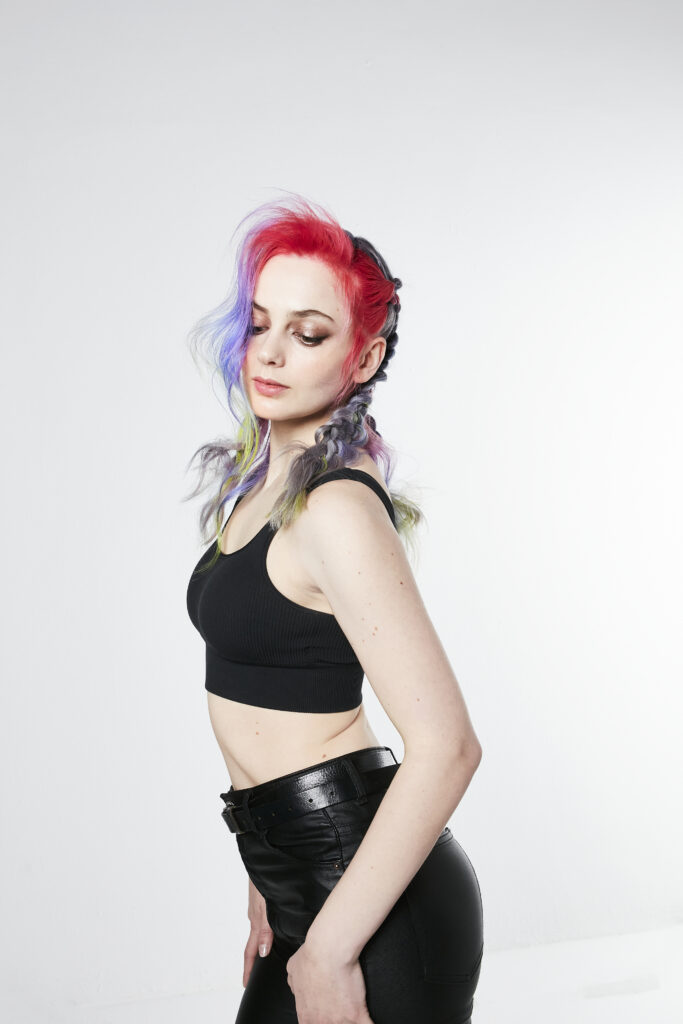 woman looking to the side with pink and purple hair and pigtails