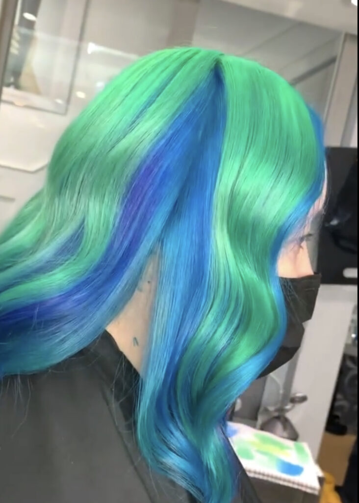 side view of womans hair that is green at the top and blue at the bottom