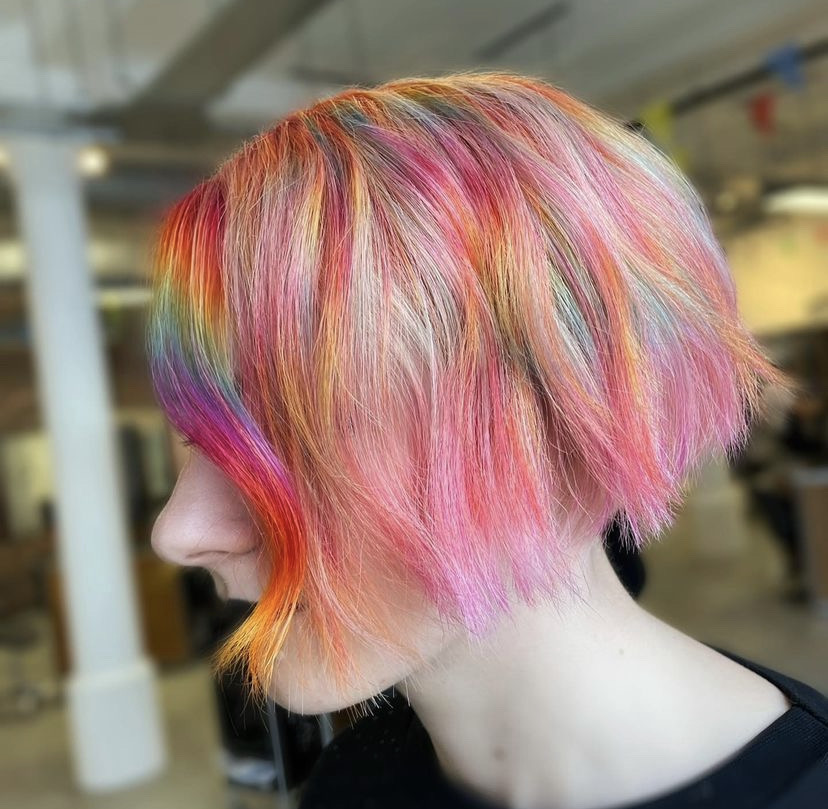 side profile of woman with rainbow coloured short hair