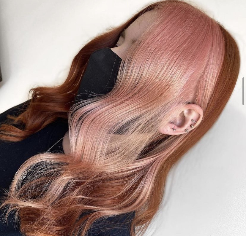 side profile of woman with long pink and peach hair