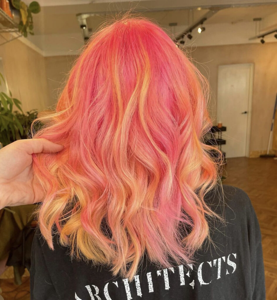 back of womans head with pink and orange curled hair