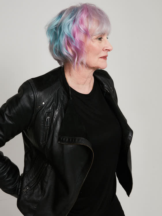 full shot of wolder woman with short pink, blue and silver hair