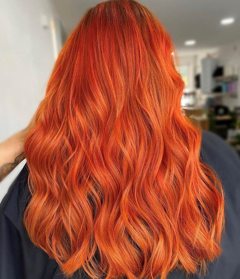back shot of a woman with long orange curled hair