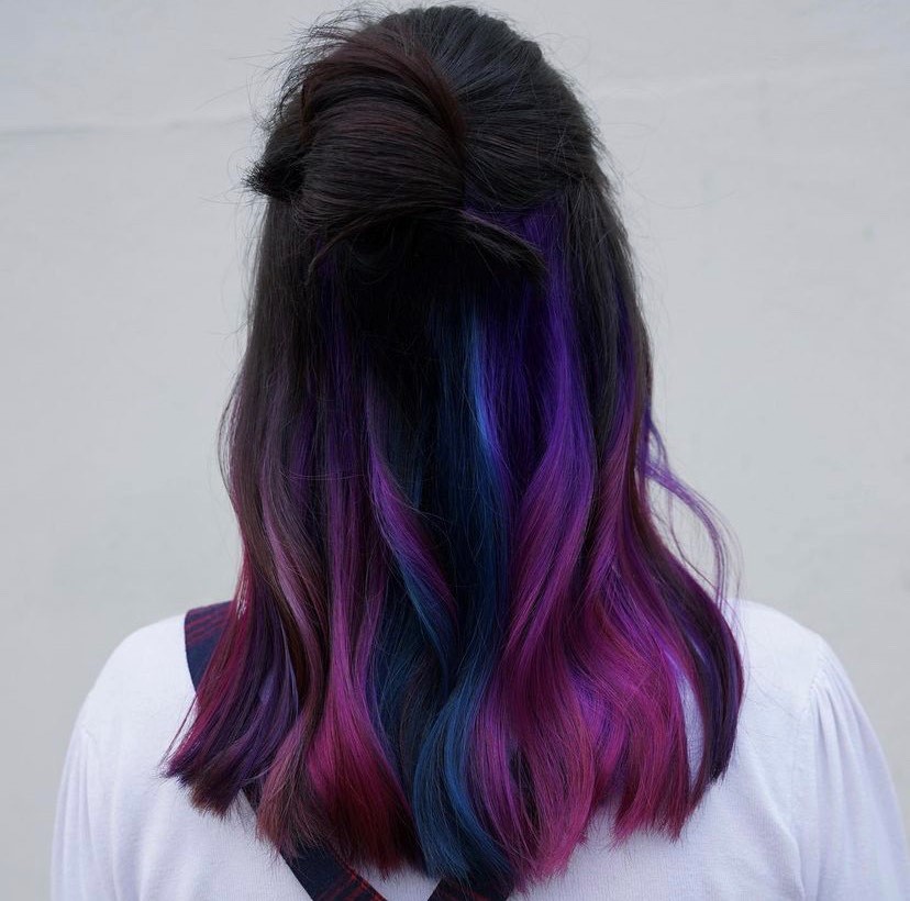 back of womans head showing dark hair blending into purple and blue