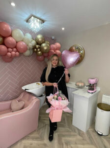 Kayleigh Clark inside her salon holding a balloon