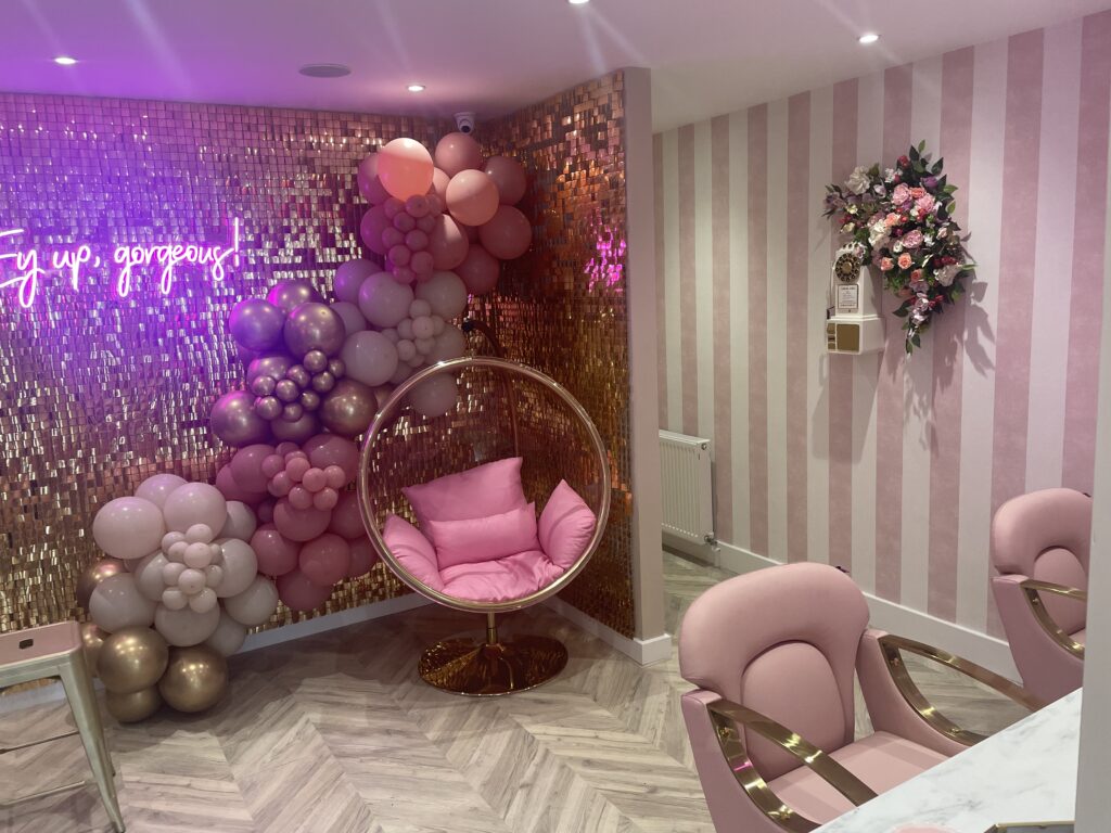 Salon interior with pink glitter wall and balloons