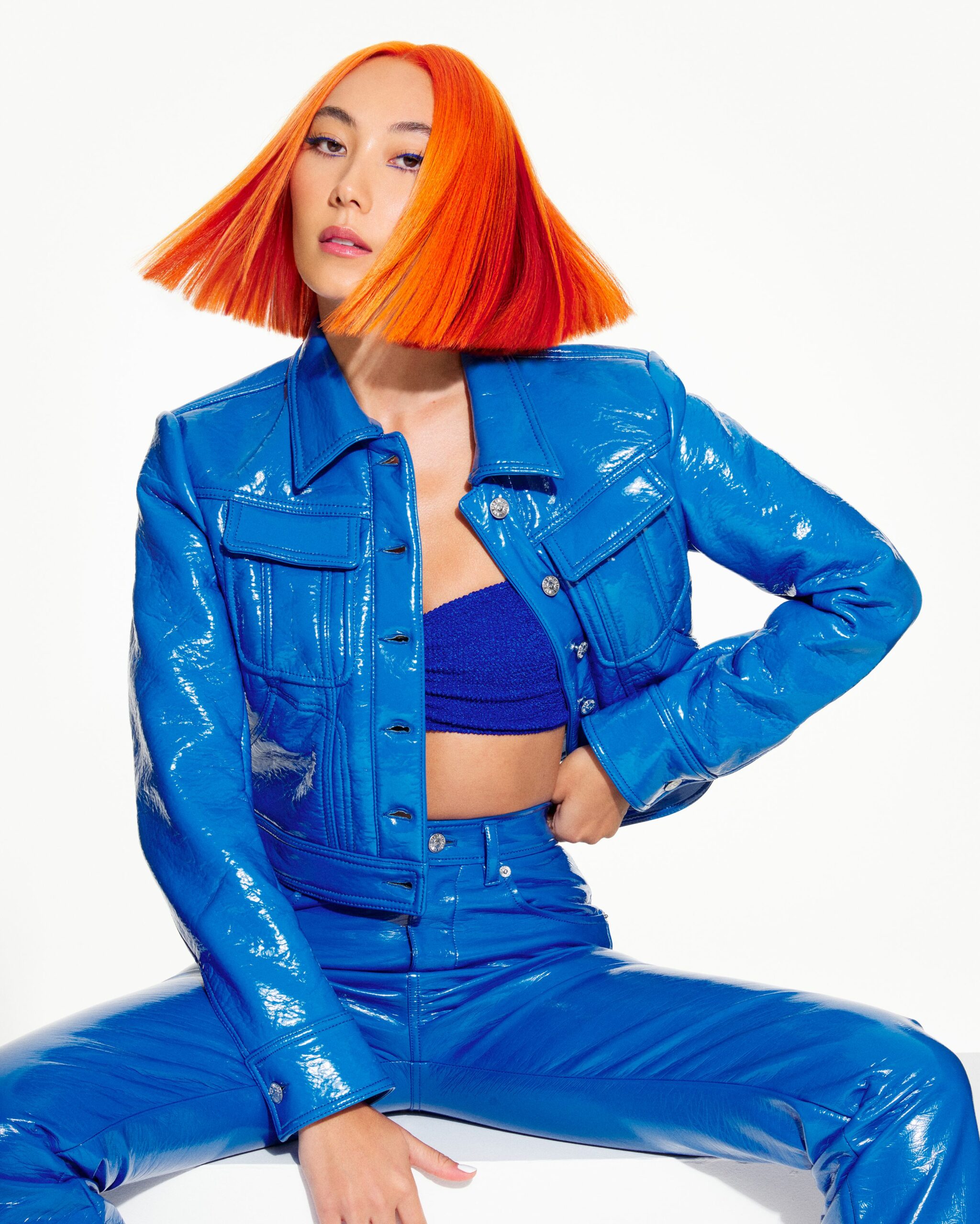 Wella Model with orange hair cut into a bob shape wearing a blue outfit.