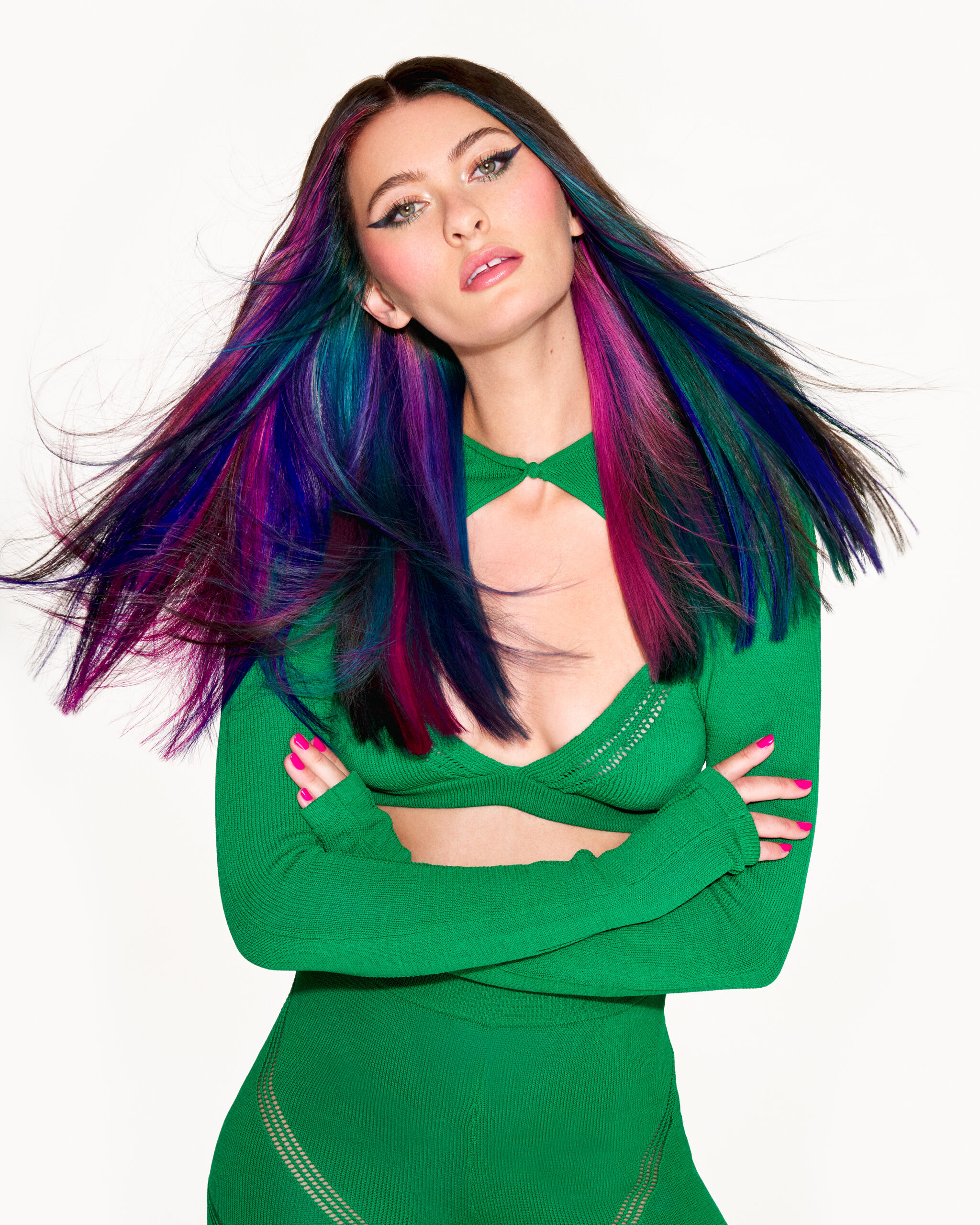 Image of model with purple, green and pink long hair wearing a green dress