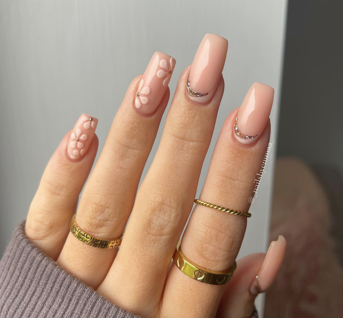 Image of square shaped pink nails with a flower print