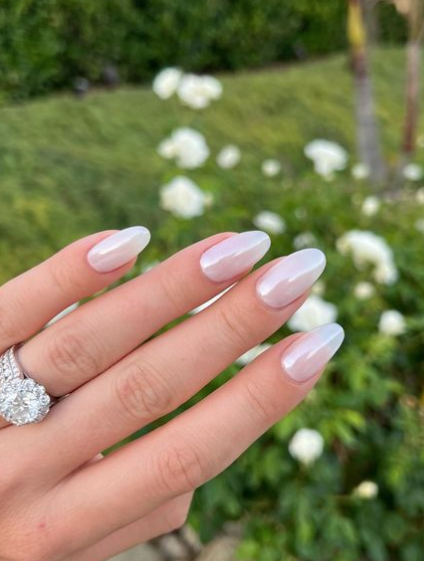 Image showing glossy nails infront of a green plant