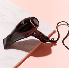 A picture of a rose gold hairdryer on a table